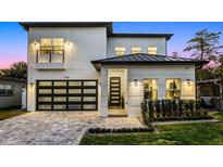 Stunning two-story home with a modern design, featuring a metal roof and landscaped front yard at 1606 Hart Ln, Orlando, FL 32804