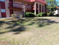 Exterior view of condo building with grassy lawn at 2860 N Powers Dr # 8, Orlando, FL 32818