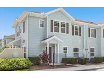 Two-story light-blue townhome with dark-brown trim and a small front yard at 5368 Diplomat Ct # 104, Kissimmee, FL 34746