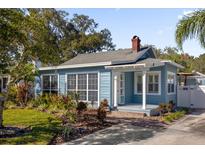 Charming bungalow style home with light blue siding, landscaping, and a brick walkway at 1575 George St, Orlando, FL 32806