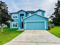 Two-story house with blue exterior, two-car garage, and well-maintained lawn at 29 Catalina Ct, Kissimmee, FL 34758