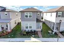 Two-story house with gray siding, light-blue door, and small front yard at 4704 Homestead Trl, Saint Cloud, FL 34772