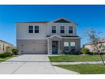 Two-story house with gray siding, a two-car garage, and a well-manicured lawn at 5420 Siltstone St, Lakeland, FL 33811