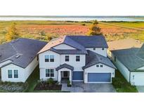 Two-story house with gray siding and a blue garage door, viewed from above at 2609 Mead Ave, St Cloud, FL 34771