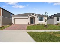 One-story home with brick paver driveway and landscaped lawn at 2740 Sweet Acacia Dr, Clermont, FL 34711
