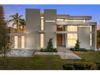 Modern home with sleek design, light color, and a landscaped lawn at 2661 Via Tuscany, Winter Park, FL 32789