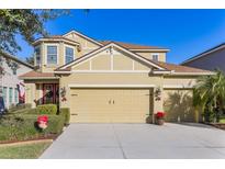 Two-story house with three-car garage, landscaping, and a red door at 1426 Plumgrass Cir, Ocoee, FL 34761