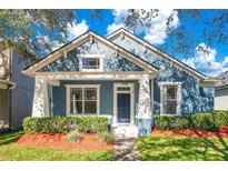 Beautiful blue house with white accents, landscaping, and a welcoming front porch at 14643 Tanja King Blvd, Orlando, FL 32828