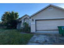 Tan house with a two-car garage and a spacious front yard at 3481 Cornell Ter, Deltona, FL 32738