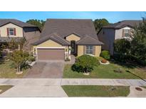 Two-story house with brown roof, beige walls, and a two-car garage at 2532 Civitas Pl, Casselberry, FL 32707