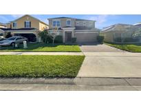 Two-story house with a paved driveway and a well-maintained lawn at 4718 Rockvale Dr, Kissimmee, FL 34758