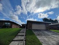 Brick ranch home with attached garage and well-manicured lawn at 661 Lake Carolyn Cir, Lakeland, FL 33813