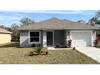 Newly constructed home with gray siding, attached garage, and landscaping at 6929 Central Ave, Mulberry, FL 33860