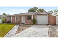 Brick ranch home with attached garage and landscaped lawn at 7710 Tern Dr, Orlando, FL 32822