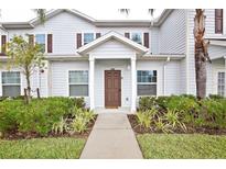 Two-story home with brown door and landscaping at 8953 Shine Dr, Kissimmee, FL 34747