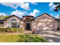 Single-story house with a two-car garage and landscaped front yard at 122 Savannah Park Loop, Casselberry, FL 32707