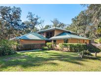 Two-story house with wood siding, green metal roof, and landscaped yard at 148 Ross Lake Ln, Sanford, FL 32771