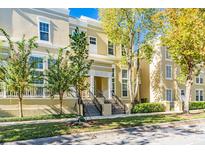 Tan two-story townhouses with mature trees and manicured landscaping at 418 Water St, Kissimmee, FL 34747