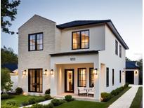 Two-story house with light stone and white exterior, black windows, and landscaped lawn at 803 Yates St, Orlando, FL 32804