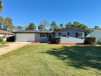 Newly painted light blue house with a neatly landscaped lawn at 1545 Culverhouse Dr, Daytona Beach, FL 32117