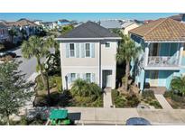 Charming two-story home with a light beige exterior and blue shutters, situated in a community with palm trees at 2972 Salted Rim Rd, Kissimmee, FL 34747