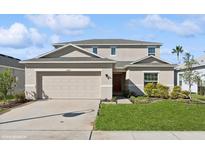 Two-story house with beige siding, a two-car garage, and landscaping at 5286 Tuscany Ln, Davenport, FL 33897