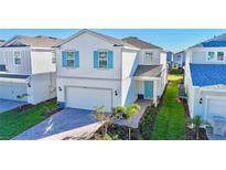 Two-story house with light blue accents and a paved driveway at 16230 Trinidad Way, Clermont, FL 34714