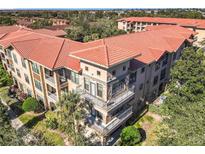 Aerial view of condo building, showing building exterior, landscaping, and community features at 904 Charo Pkwy # 525, Davenport, FL 33897
