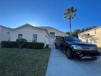 Two-story house with attached garage and a spacious driveway, surrounded by manicured landscaping at 612 Bloomingdale Dr, Davenport, FL 33897