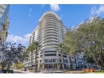 Modern high-rise building with palm trees and city views at 100 S Eola Dr # 1411, Orlando, FL 32801