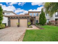 Two-story home with stone accents and a two-car garage, beautifully landscaped at 15939 Vetta Dr, Bella Collina, FL 34756