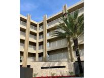 Tan three-story building with balconies and palm trees at 4501 S Atlantic Ave # 4090, New Smyrna Beach, FL 32169