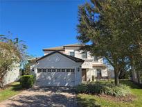 Two-story house with a large garage and well-manicured lawn at 9037 Shadow Mountain St, Davenport, FL 33896