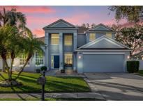 Two-story house with gray siding, a three-car garage, and a manicured lawn at 1813 Sugar Cove Ct, Ocoee, FL 34761