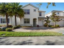 Two-story house with a white exterior, two palm trees, and a brick driveway at 4738 Sleepy Hollow Dr, Kissimmee, FL 34746