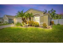 Well-maintained house with landscaped front yard, palm trees, and a two-car garage at 1704 Setting Sun Loop, Casselberry, FL 32707