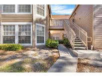 Exterior view of condo building showcasing stairs and landscaping at 696 Youngstown Pkwy # 307, Altamonte Springs, FL 32714