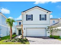 Two-story house with gray shutters, white siding, and a paved driveway at 7212 Oakmoss Loop, Davenport, FL 33837