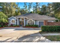 Gray house with a gray roof, brick wall, and landscaping at 9302 Bay Vista Estates Blvd, Orlando, FL 32836