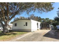 Single-wide mobile home with carport and mature tree in front at 165 Moss Dr, Debary, FL 32713
