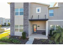 Contemporary townhome with gray facade and modern entryway at 1264 Challenge Dr, Davenport, FL 33896
