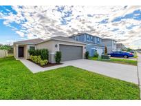 One-story house with gray garage door and landscaped front yard at 591 Preserve Pointe Blvd, Davenport, FL 33837