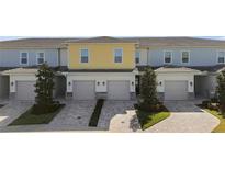 Three-unit townhome building with attached garages and landscaped grounds at 856 Driving Range Ct, Reunion, FL 34747