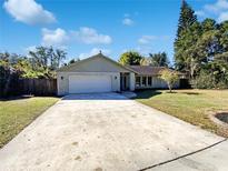 House exterior featuring a light-grey facade, white garage door, and a well-maintained lawn at 4026 Tenita Dr, Winter Park, FL 32792