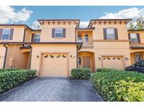 Tan two-story townhome with attached garage and landscaping at 2020 Retreat View Cir, Sanford, FL 32771