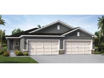 Two-story home with gray siding, three-car garage, and landscaping at 2619 Kinsale Ln, Ormond Beach, FL 32174