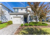 Two-story house with blue shutters, a white exterior, and a landscaped lawn at 1593 Mulligan Blvd, Davenport, FL 33896