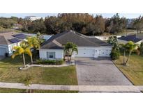 Aerial view of a single-Gathering home with a paved driveway and landscaped yard at 402 Blue Lake Cir, Kissimmee, FL 34758