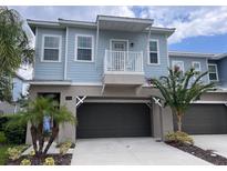 Two-story light blue house with dark brown garage door and balcony at 556 Lake Wildmere Cv, Longwood, FL 32750