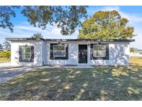 Newly renovated home with a modern facade and well-manicured lawn at 4201 Lake Lawne Ave, Orlando, FL 32808